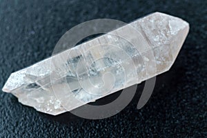 Natural mineral from geological collection raw clear quartz rock crystal stone, black background, close up macro