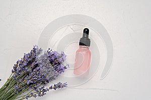 Natural oil in dripping bottle and lavender flowers isolated on white background. Cosmetic product. Aromatherapy. Flat