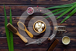 Natural oil for hair near bottles and brush on wooden background top view pattern