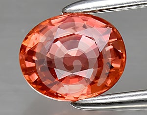 natural orange padparadscha sapphire gem on the background photo