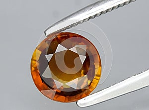 natural orange tourmaline dravite gem on the background