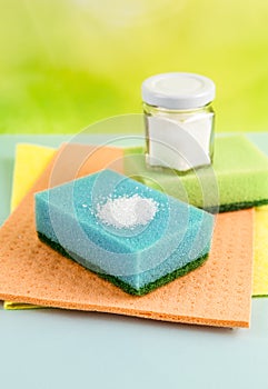 Natural organic citric acid cleaning products concept. White Citric acid powder on blue washing sponge and in jar.