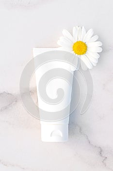 Natural organic cosmetic packaging mock up with flowers of camomile. Hand cream or lotion for softening skin