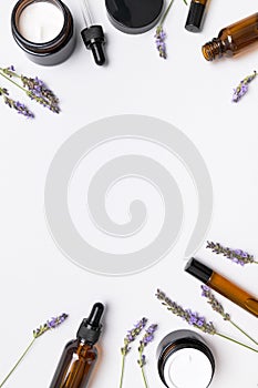 Natural organic cosmetics with lavender extract on white background flat lay top view. Glass bottles with pipette, jars of face