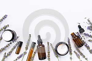 Natural organic cosmetics with lavender extract on white background flat lay top view. Glass bottles with pipette, jars of face