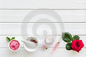 Natural organic cosmetics with rose extract on white wooden background top view copyspace