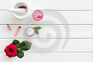 Natural organic cosmetics with rose extract on white wooden background top view copyspace