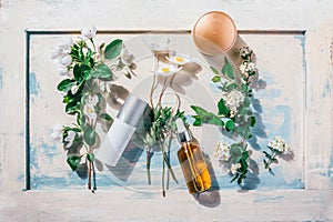 Natural organic cosmetics: serum, cream, mask on wooden background with flowers. Skincare concept