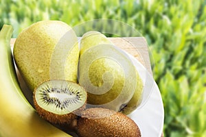 Natural organic fruits on wooden table in nature. Top view on green grasses with copy space. Rustic lifestyle concept