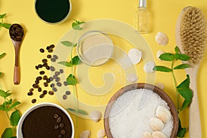 Natural organic ingredients-sea salt, coffee scrub, honey and a hard body brush on a yellow background. home skin care for