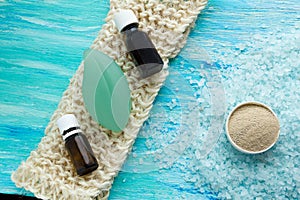 Natural organic soap bottles essential oil and sea salt herbal bath on a blue wooden table