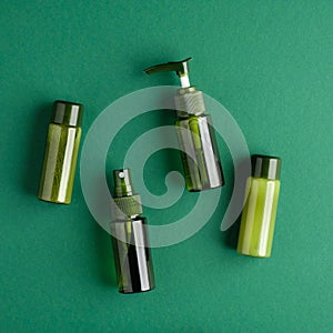 Natural organic SPA beauty products set on green background. Top view green cosmetic bottles, packaging design