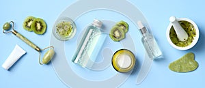 Natural organic SPA cosmetic products set with kiwi fruit. Top view herbal skincare beauty products on blue background. Banner for