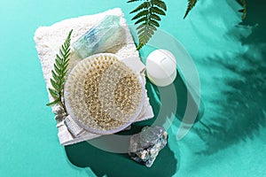 Natural organic wooden body massage brush, crystals, towel, fern leaves with natural sunlight. Home Spa Therapy.