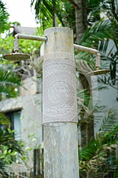 Natural outdoor shower head mounted on a wooden pole designed for showering before jumping into the resort pool.Outdoor shower