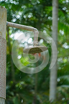 Natural outdoor shower head mounted on a wooden pole designed for showering before jumping into the resort pool.Outdoor shower