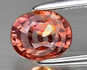natural padparadscha orange sapphire gem on the background photo