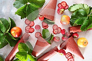Natural pastille rolled into a cone. Apples and strawberry leaves on a light background. Copy of the space.The view from the top