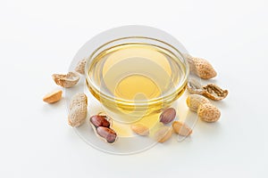 Natural peanut oil in a bowl with peanuts