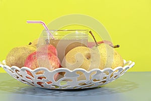 Natural pear juice and fruits of different varieties on yellow background photo