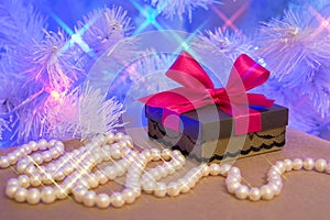 Natural pearl garland and a gift wrapped present with red bow