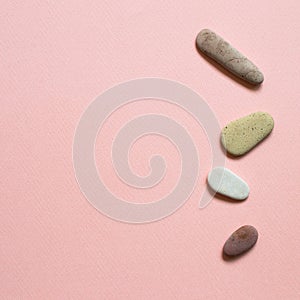 Natural pebble stones on pink background