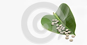 Natural pills on green leaf.