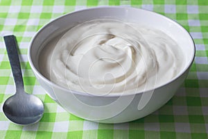 Natural plain white Greek yoghurt in bowl closeup - Yogurt background photo