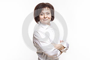 Natural Portrait of Smiling Mature Confidant Brunette Caucasian Business Woman in Whitre Shirt Posing With Hands Folded On White