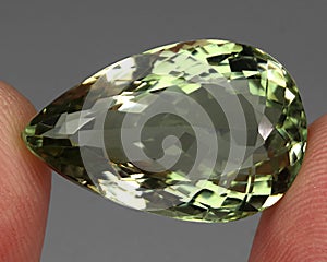 Natural precious green amethyst prasiolite on a gray background