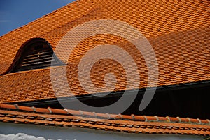 Natural red roof tiles on barn roof and a wall