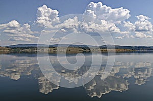 Natural reflection on Vlasina Mountain Lake and beautiful cloudy sky