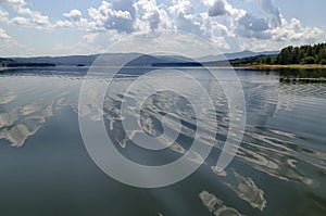 Natural reflection on Vlasina Mountain Lake and beautiful cloudy sky