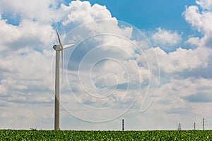 Natural resource concept. Renewable energy produced in rural area. Wind turbine in green field