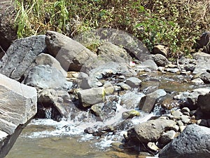 A natural river landscape flowing calmly filled with stones of various sizes
