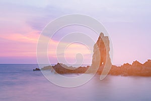 Natural rock over sea shore skyline after sunset tone