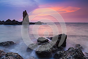 Natural rock over seacoast with sunset sky background