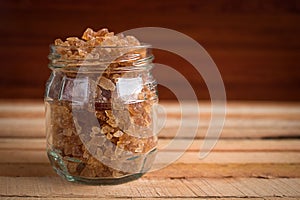 Natural rock sugar in glass bottle on rustic table