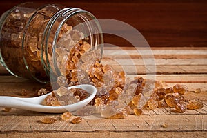 Natural rock sugar in glass bottle on rustic table