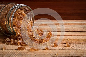 Natural rock sugar in glass bottle on rustic table