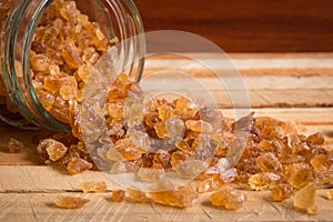 Natural rock sugar in glass bottle on rustic table