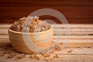 Natural rock sugar in wooden bowl on rustic table