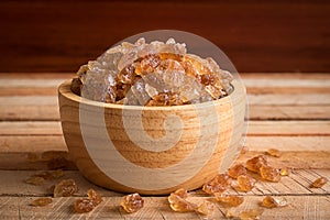 Natural rock sugar in wooden bowl on rustic table