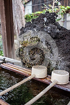 A natural rocky chozu hand washing basin at a Shinto Shrine in Japan