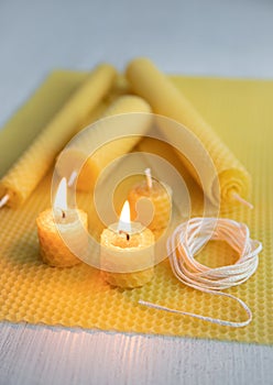 Natural rolled beeswax candles from pressed beeswax honeycomb sheet at home indoors.