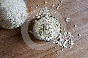 Natural rolled oats piled in bowl and in storage jar