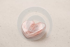 Natural rose quartz heart stone on light background. Natural stones, crystals for magic, lithotherapy, geology, minerals, stone