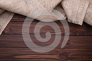 Natural sackcloth on brown wooden background. Canvas on brown wooden table