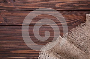 Natural sackcloth on brown wooden background. Canvas on brown wooden table