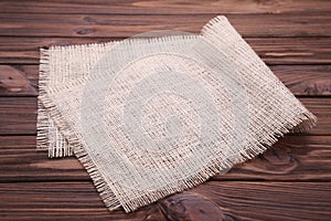 Natural sackcloth on brown wooden background. Canvas on grey wooden table